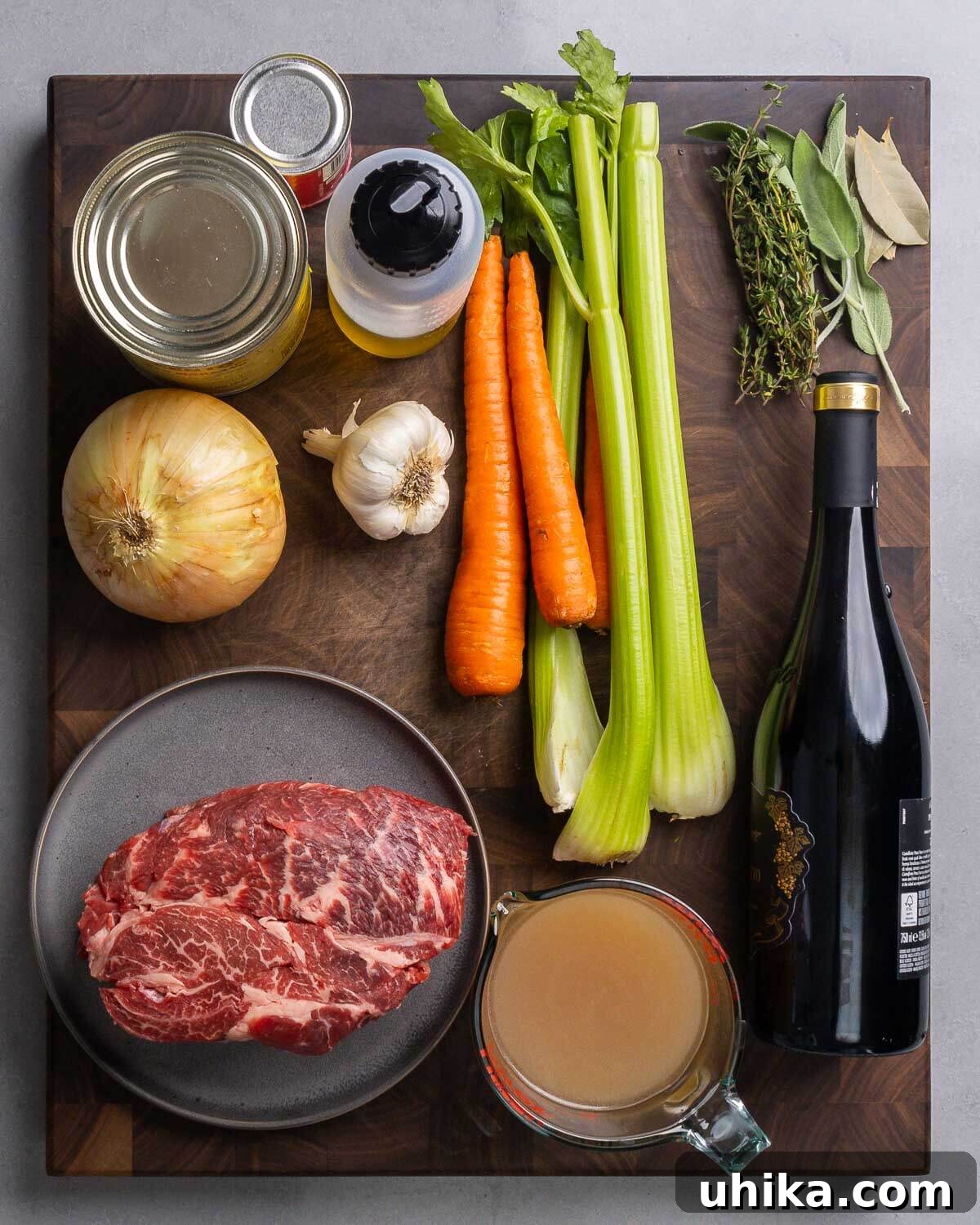 Stracotto Slow-Cooked Italian Pot Roast 3 Ingredients shown: canned tomatoes, olive oil, carrots, celery, herbs, onion, garlic, chuck roast, beef stock, and bottle of red wine.