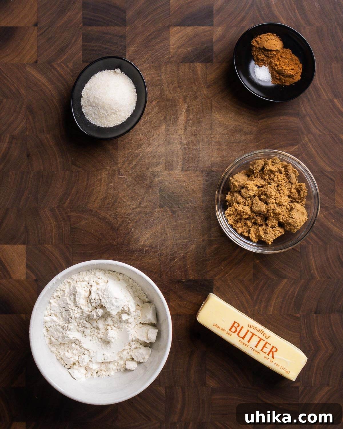 Autumn Pumpkin Crumble Muffins 3 Crumb topping ingredients laid out: granulated sugar, brown sugar, all-purpose flour, ground cinnamon, pumpkin pie spice, and unsalted butter.