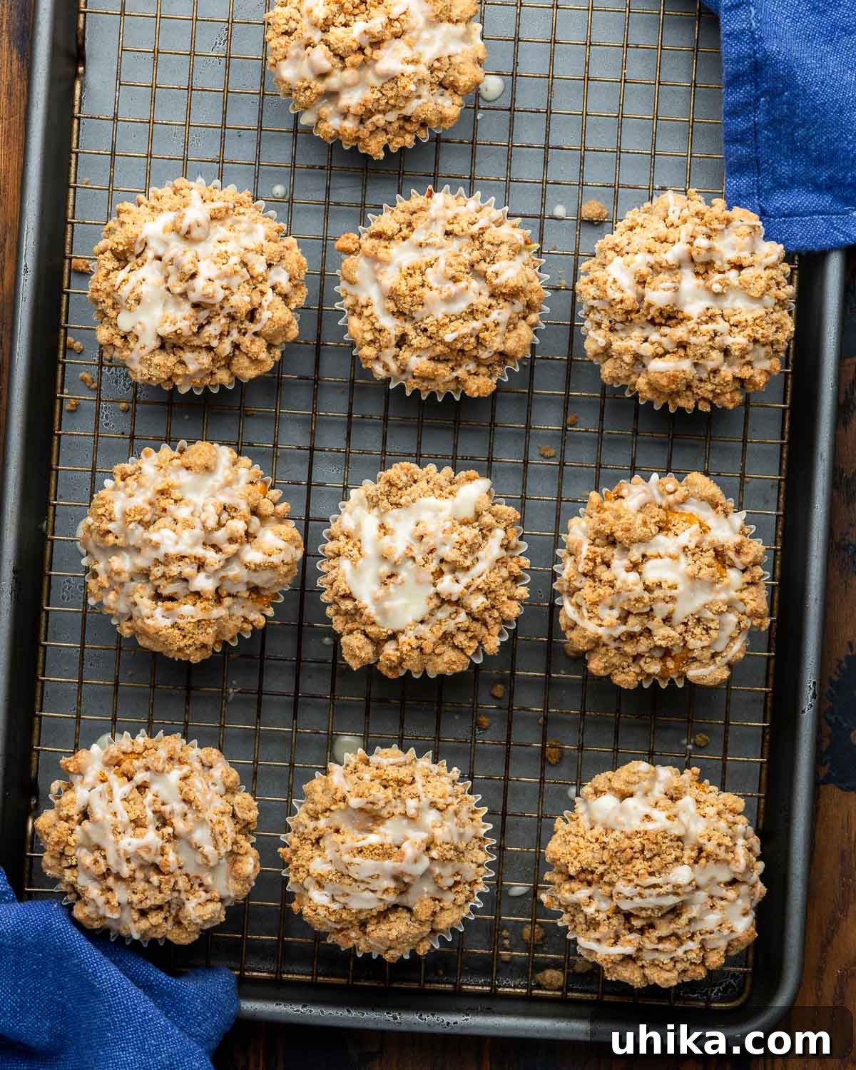 Autumn Pumpkin Crumble Muffins 7 Glazed pumpkin crumb muffins displayed on a wire rack, ready to be served.