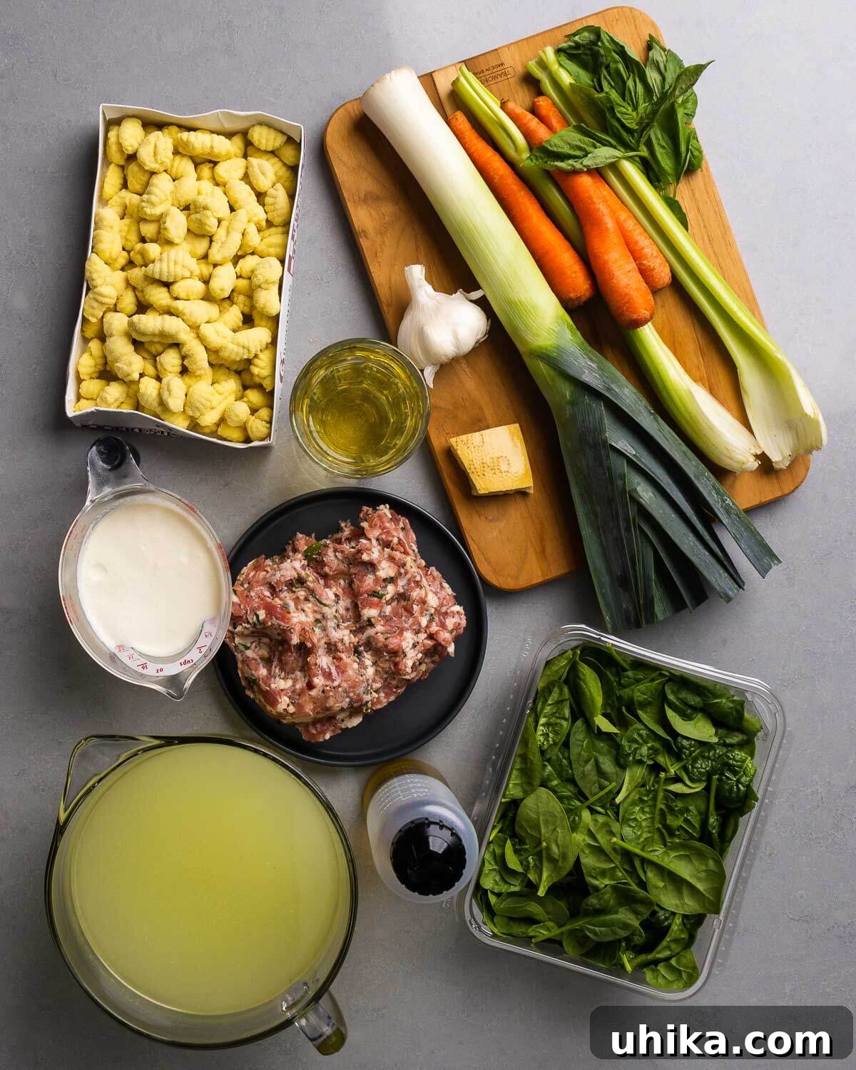 Hearty Sausage Gnocchi Soup 3 Ingredients shown: gnocchi, white wine, garlic, parmesan rind, leek, carrots, celery, basil, cream, bulk Italian sausage, chicken stock, olive oil, and baby spinach.