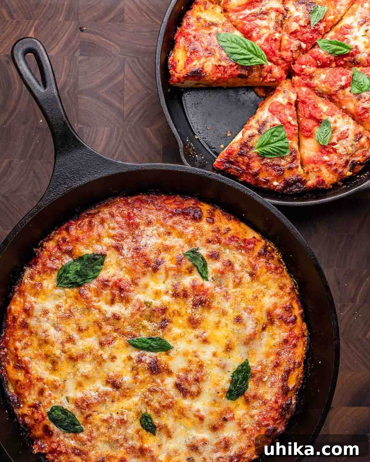 10 Must-Have Kitchen Tools for Your Fall Cooking 7 An overhead shot showcasing two perfectly cooked cast iron pan pizzas resting on a rustic walnut cutting board, highlighting the pan's versatility.