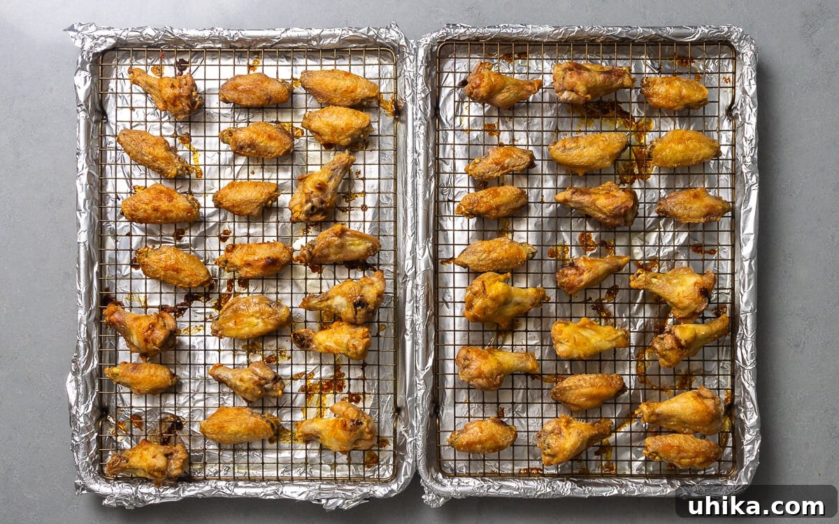 10 Must-Have Kitchen Tools for Your Fall Cooking 8 Two foil-covered baking sheets laden with crispy chicken wings, ready for the oven or just taken out.