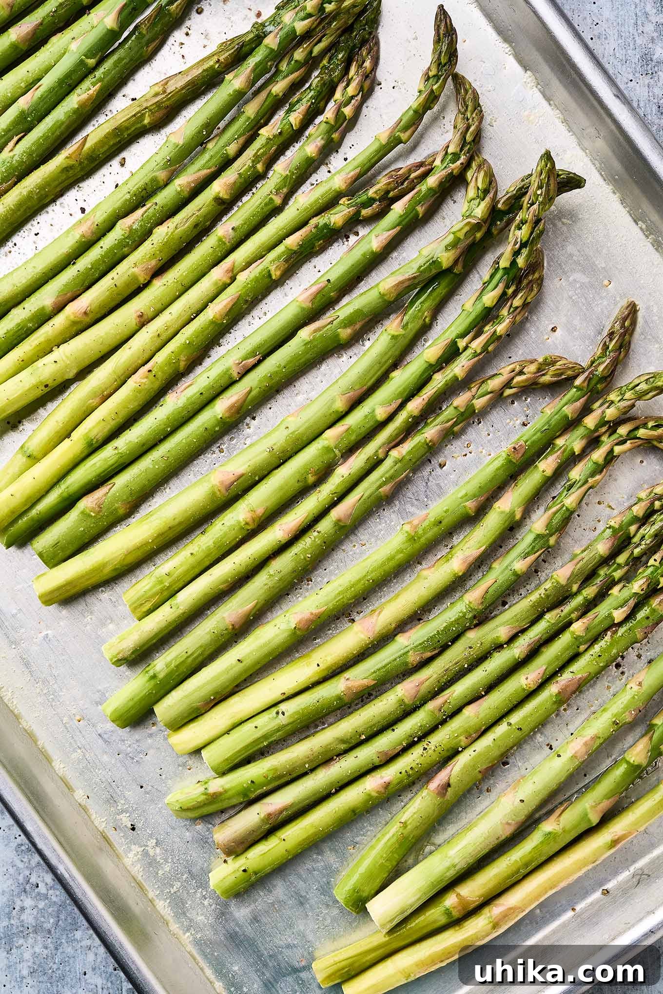 Zesty Lemon Roasted Asparagus 4 Fresh asparagus spears coated in melted butter and seasoned with salt and pepper, ready to be roasted.