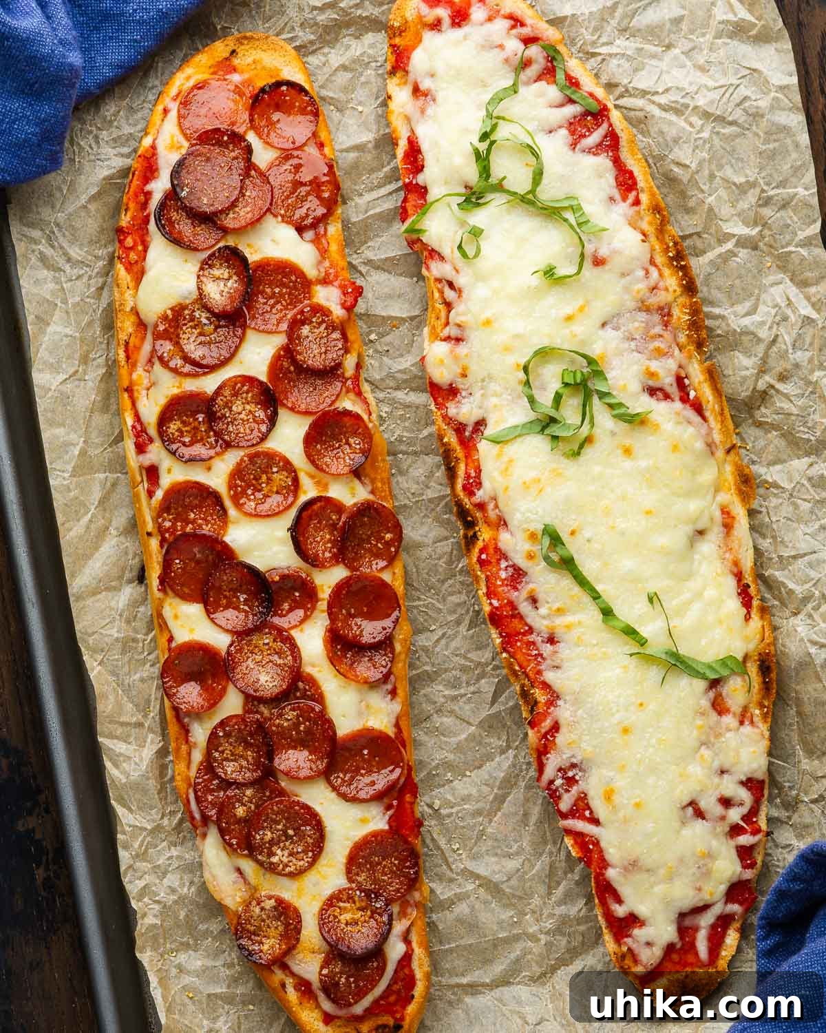 Two sides of French bread pizza with one plain and one with pepperoni.