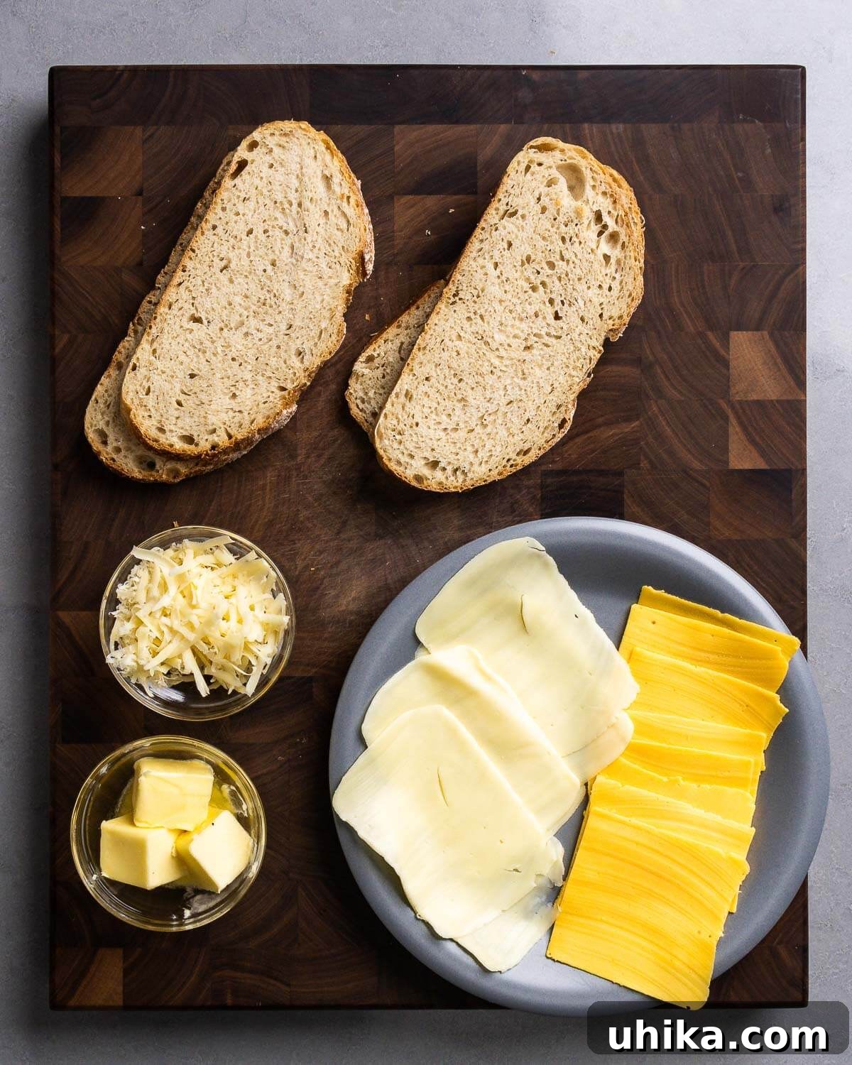 Perfectly Golden Grilled Cheese Indulgence 3 Ingredients for gourmet grilled cheese: sourdough bread, shredded Fontina, mozzarella and American cheese slices, and butter.