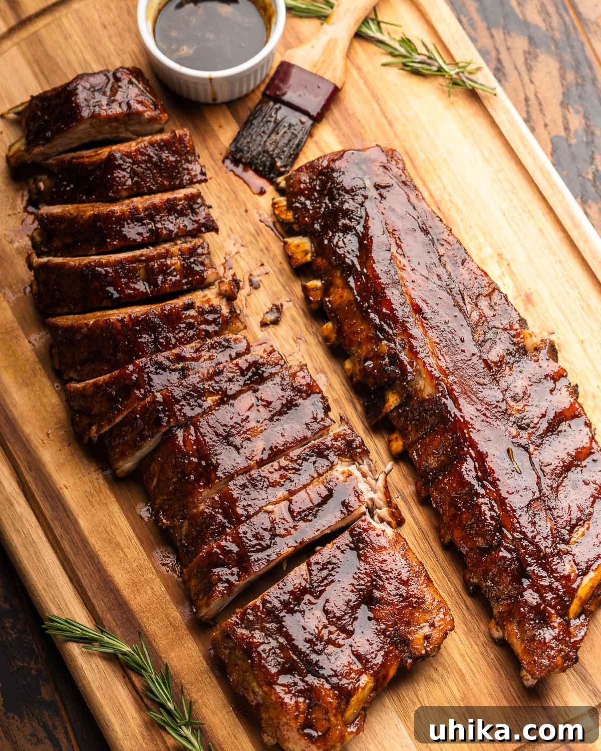Rustic Tuscan Balsamic Glazed Ribs 2 Two racks of Tuscan-style baby back ribs on cutting board with small bowl of balsamic glaze and brush.