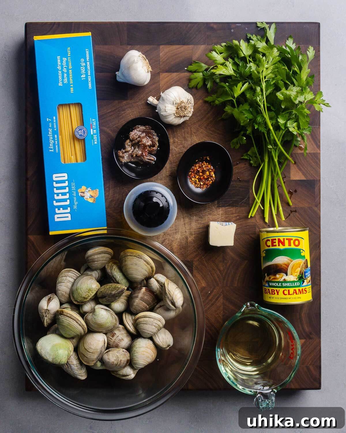 Ingredients shown: linguine, garlic, anchovies, olive oil, hot red pepper flakes, parsley, whole little neck clams, butter, can of chopped clams, and white wine.