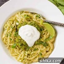 Thin spaghetti tossed with a salsa verde made with tomatillos, poblano peppers, lime, scallions, and cilantro, garnished with sour cream and a lime wedge.