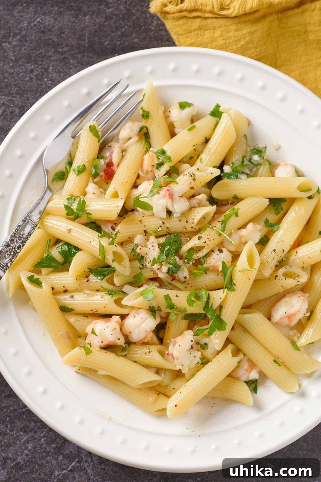 Decadent Lobster Pasta with Truffle Essence 2 A vibrant plate of penne pasta with succulent lobster pieces, glistening in a delicate white wine and butter sauce, garnished with fresh parsley.