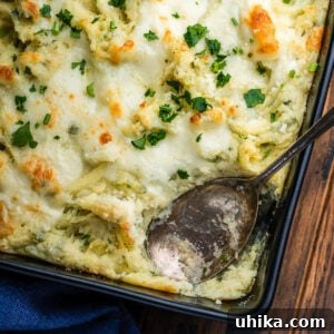 Baking dish with Italian baked mashed potatoes and spoon.
