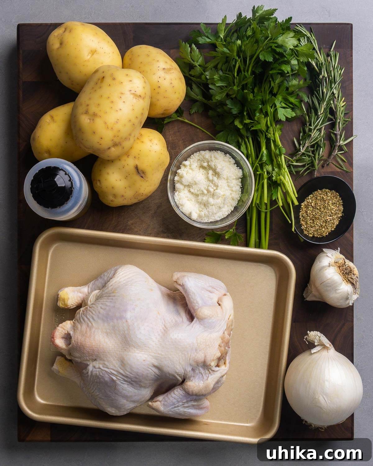 Golden Rosemary Spatchcock Chicken and Crispy Potatoes 3 Ingredients for Spatchcock Chicken and Potatoes, including fresh potatoes, olive oil, parsley, rosemary, oregano, Romano cheese, garlic, onion, and a whole chicken.