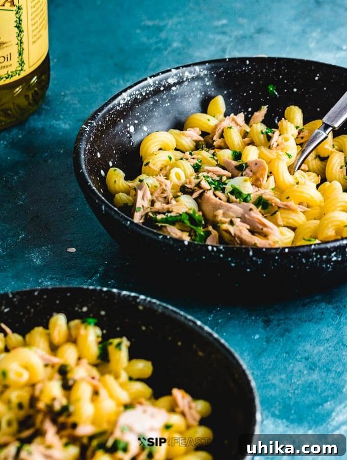 Two plates of Tuna Pasta, one with an additional drizzle of olive oil, showcasing the inviting presentation.