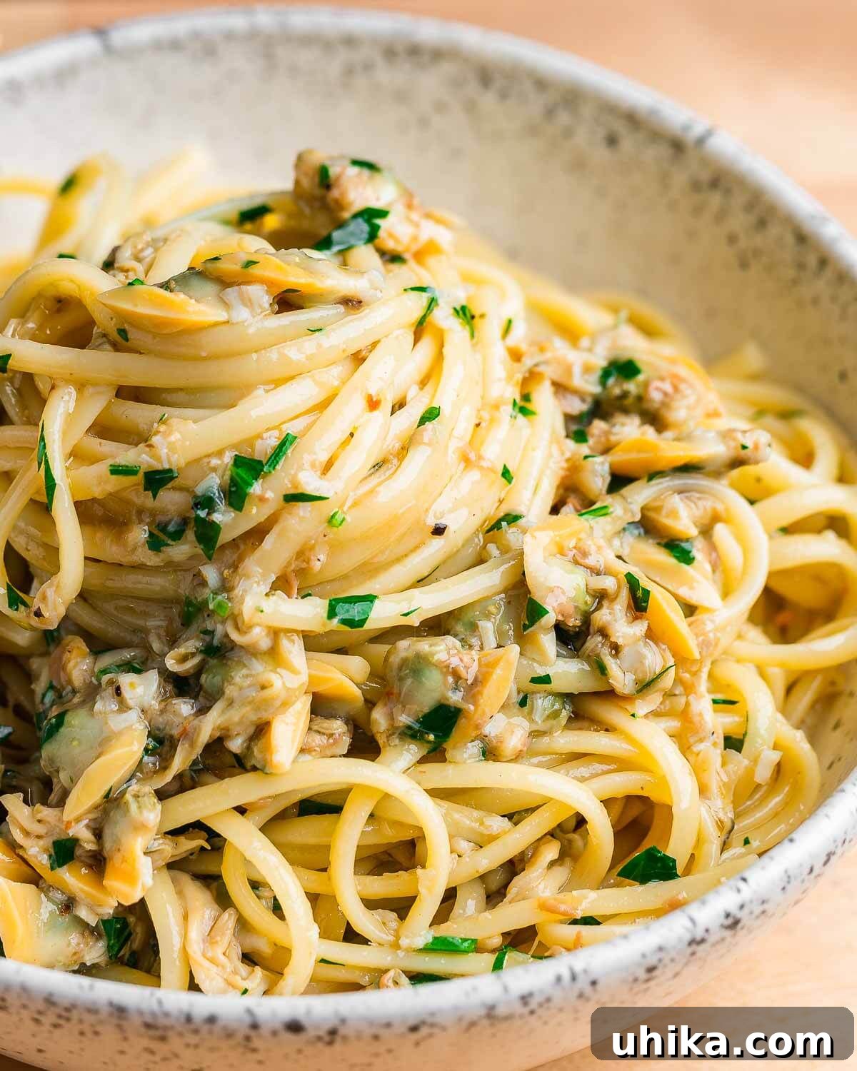 Seafood Spectacle: Recipes for Your Seven Fish Feast 6 White bowl showcasing Linguine with Canned Clams in a delectable white clam sauce, garnished and ready to serve.
