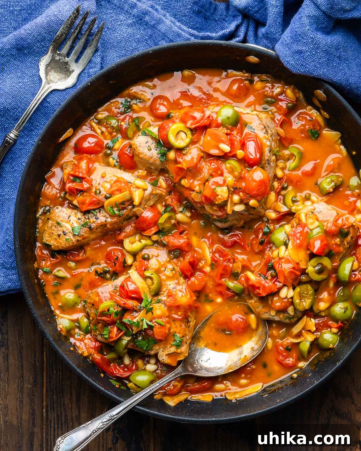 Tuna Siciliana: Olives and Capers 2 Large black pan with tuna steaks smothered in Sicilian style sauce, garnished with fresh parsley.