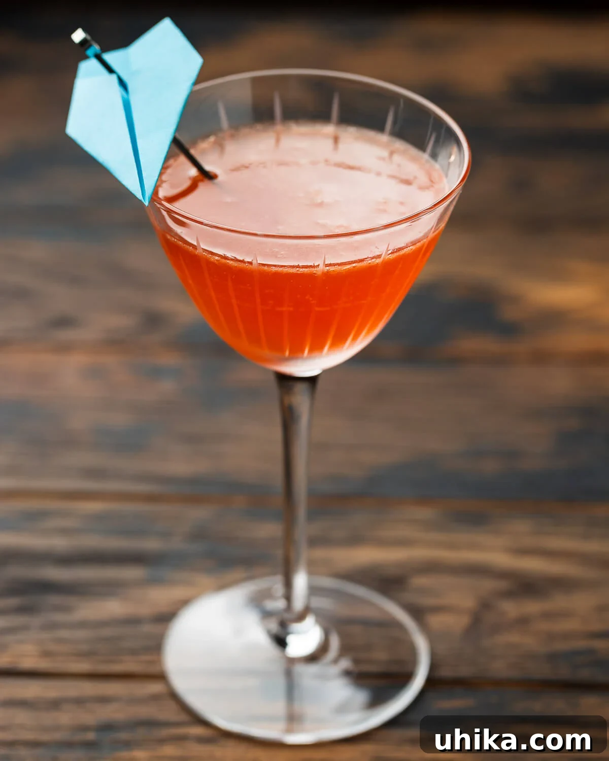 Small coupe glass with a Paper Plane cocktail, elegantly presented.