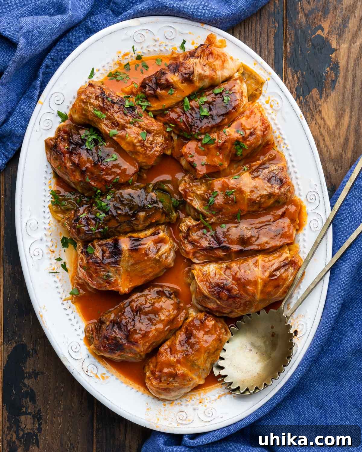Savory Cabbage Wraps 2 Large white platter with perfectly braised stuffed cabbage rolls, garnished with fresh parsley.