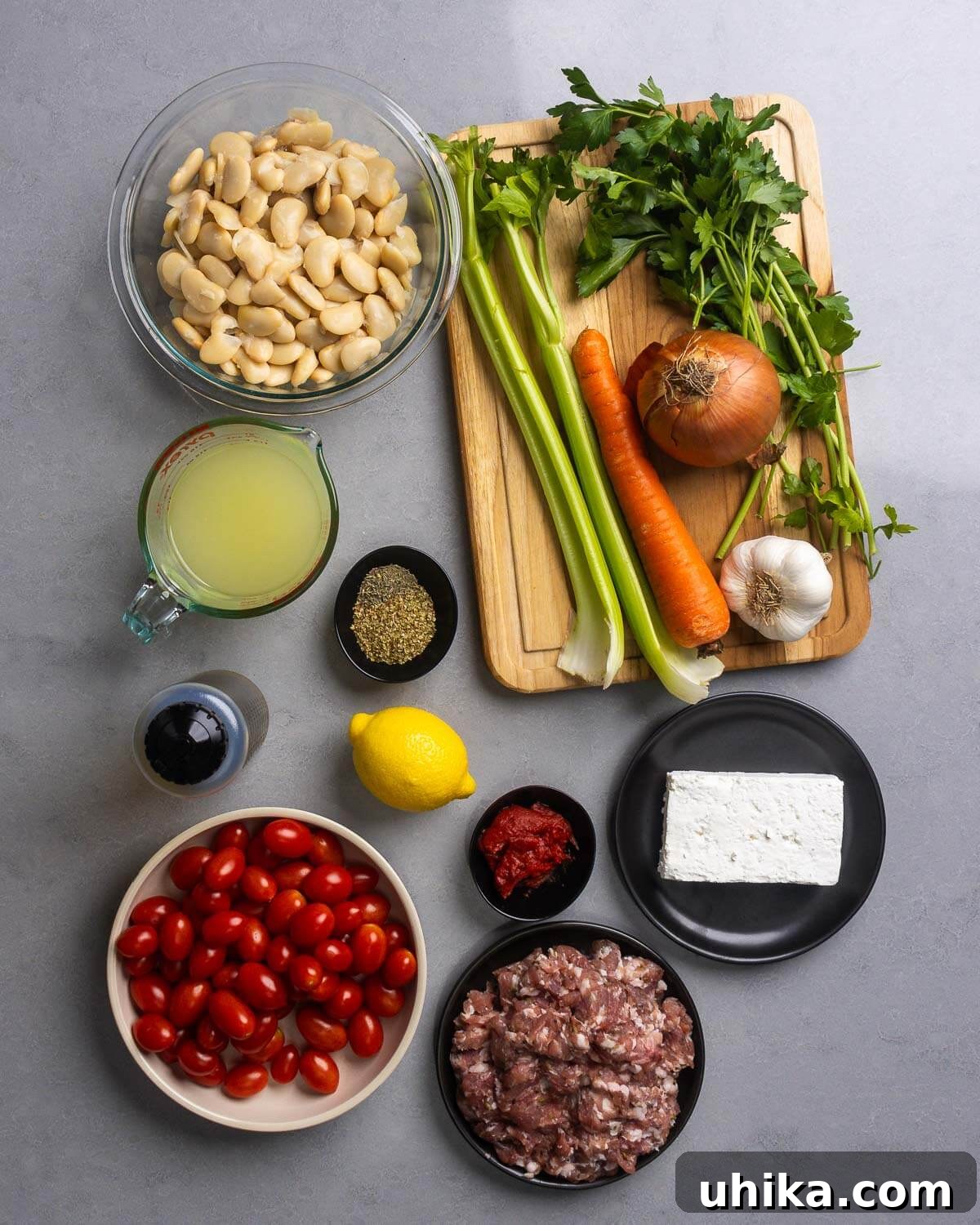 Hearty Greek Sausage and Bean Stew 3 Ingredients for Greek beans and sausage: gigantes beans, celery, carrots, parsley, onion, garlic, chicken stock, oregano, thyme, olive oil, lemon, tomato paste, feta, cherry tomatoes, and sausage.