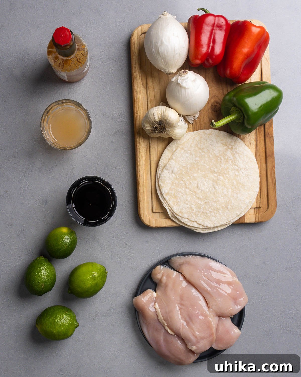 Sizzling Chicken Fajita Fiesta 3 Ingredients shown: Tabasco, pineapple juice, soy sauce, limes, onions, bell peppers, garlic, tortillas, and chicken breasts.