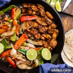 Large cast iron pan with chicken fajitas.