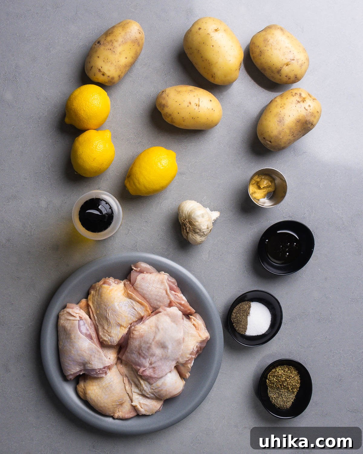 Bright Greek Lemon Chicken and Crispy Potatoes 4 Ingredients for Greek lemon chicken and potatoes: Yukon Gold potatoes, fresh lemons, olive oil, Dijon mustard, garlic, honey, bone-in skin-on chicken thighs, dried oregano, dried thyme, salt, and pepper.