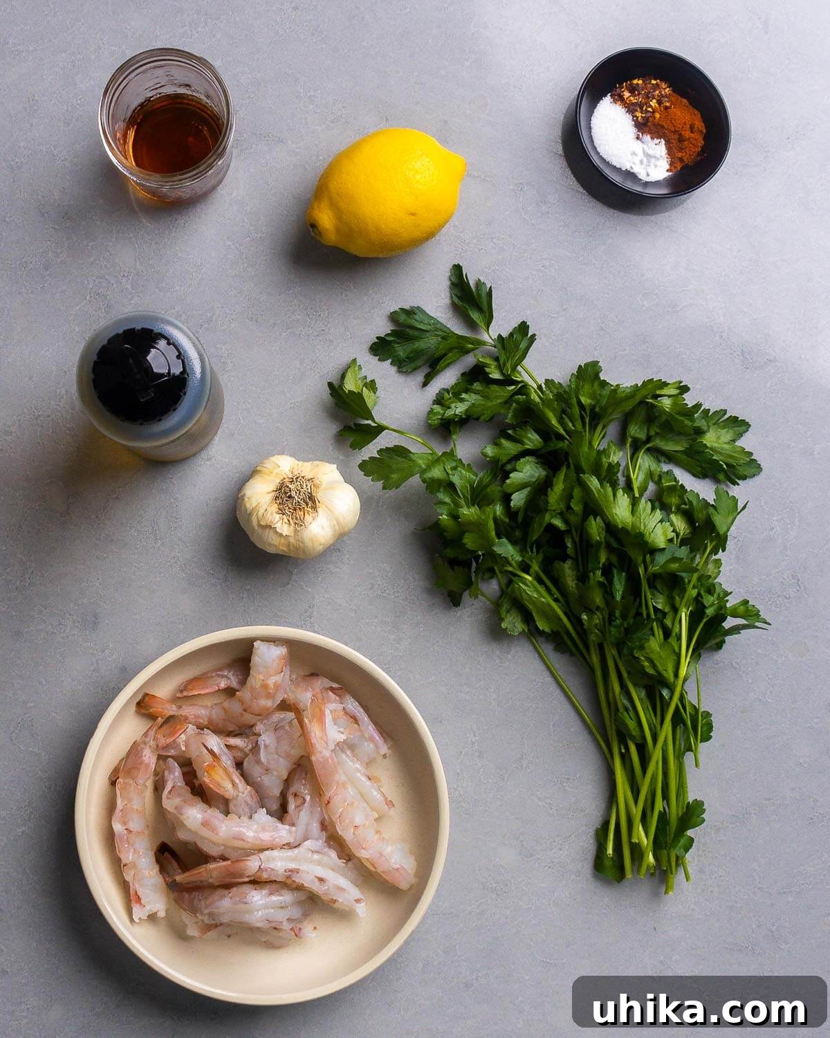 Irresistible Spanish Garlic Shrimp 3 All ingredients for Spanish garlic shrimp are laid out: sherry, lemon, hot red pepper flakes, smoked paprika, salt, baking soda, olive oil, garlic, parsley, and raw colossal shrimp.