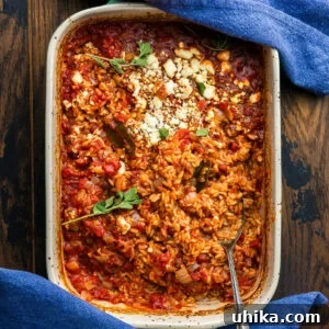 Baking dish with baked orzo with blue napkins.
