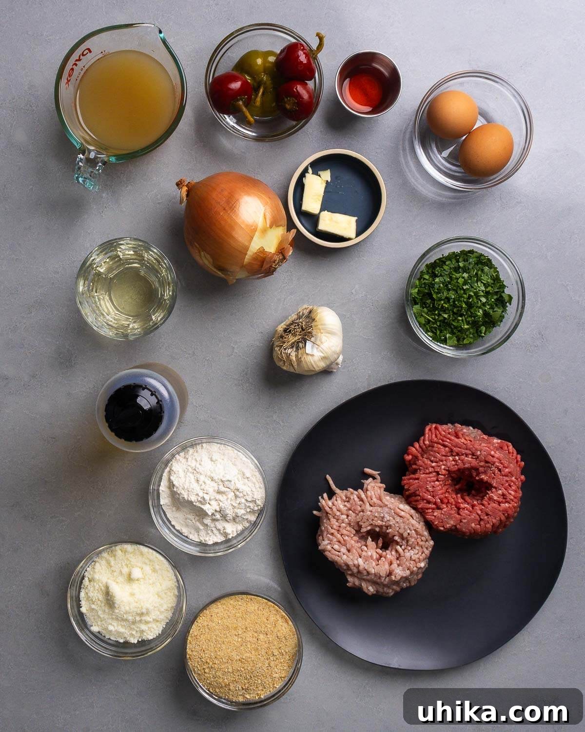 Perfect Pan Fried Meatballs 4 Ingredients shown: chicken stock, cherry peppers, vinegar, eggs, butter, onion, white wine, garlic, parsley, olive oil, flour, pecorino cheese, breadcrumbs, ground beef, and ground pork.