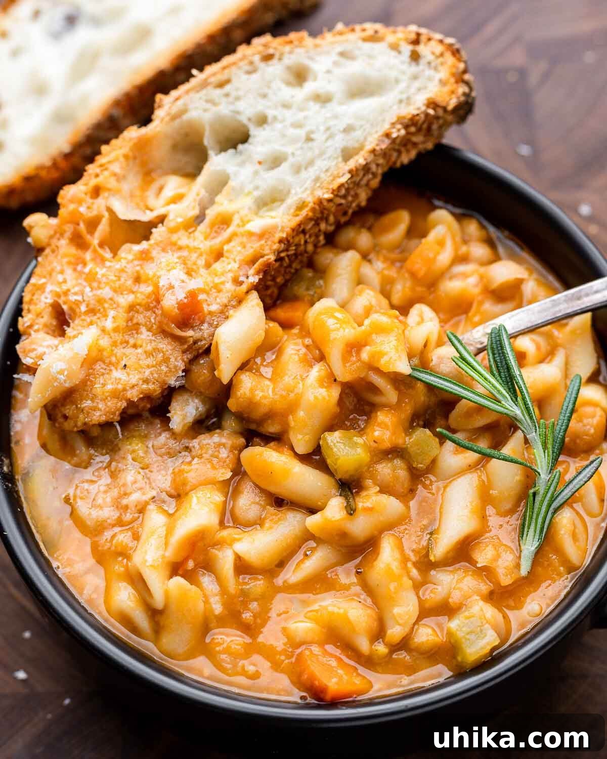 Hearty Pasta and Chickpeas 2 Overhead shot of black bowl with pasta e ceci and piece of bread.