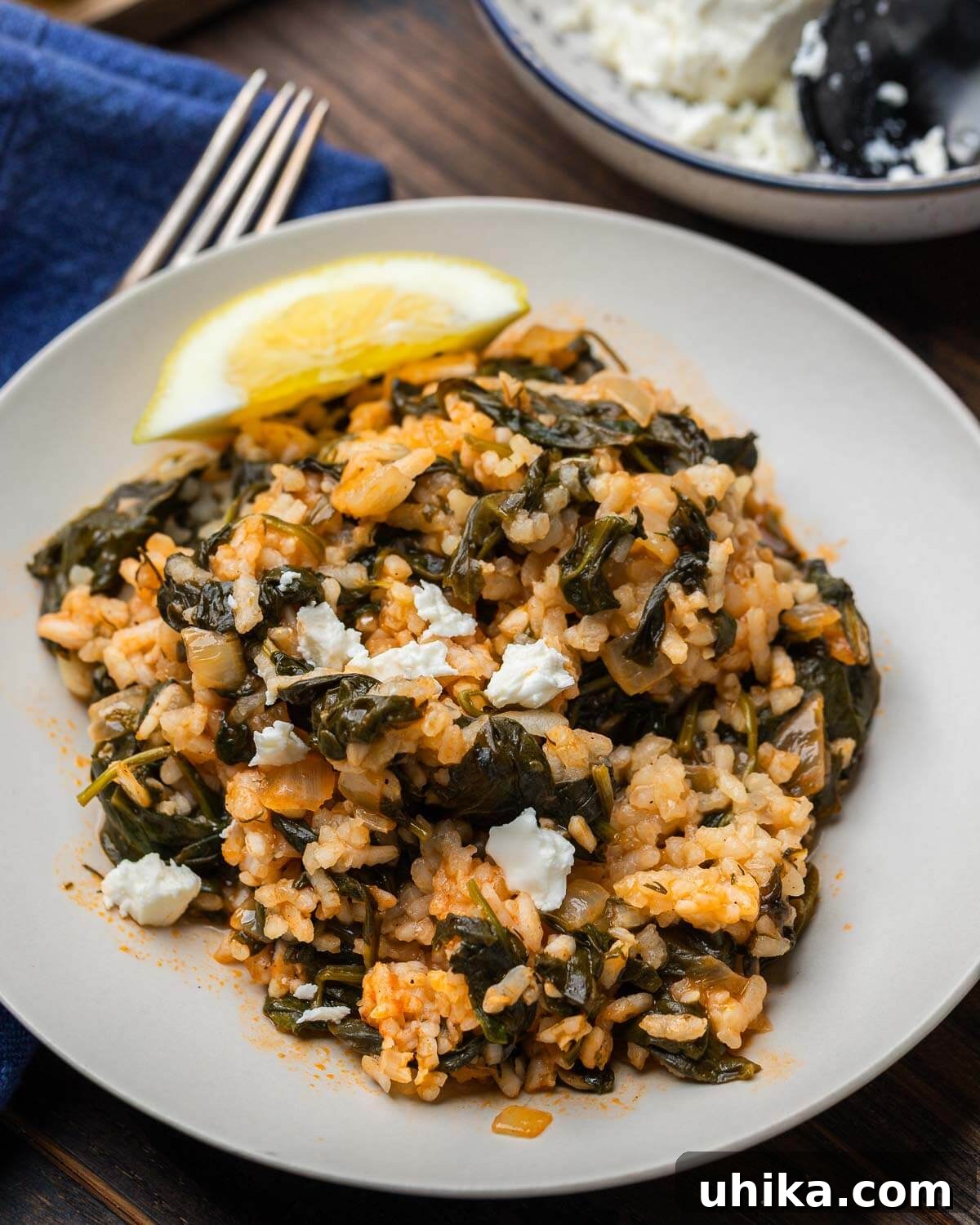 Spanakorizo: Effortless One-Pot Greek Rice 2 Spanakorizo on white plate with feta and lemon wedge garnish, highlighting its fresh appeal.