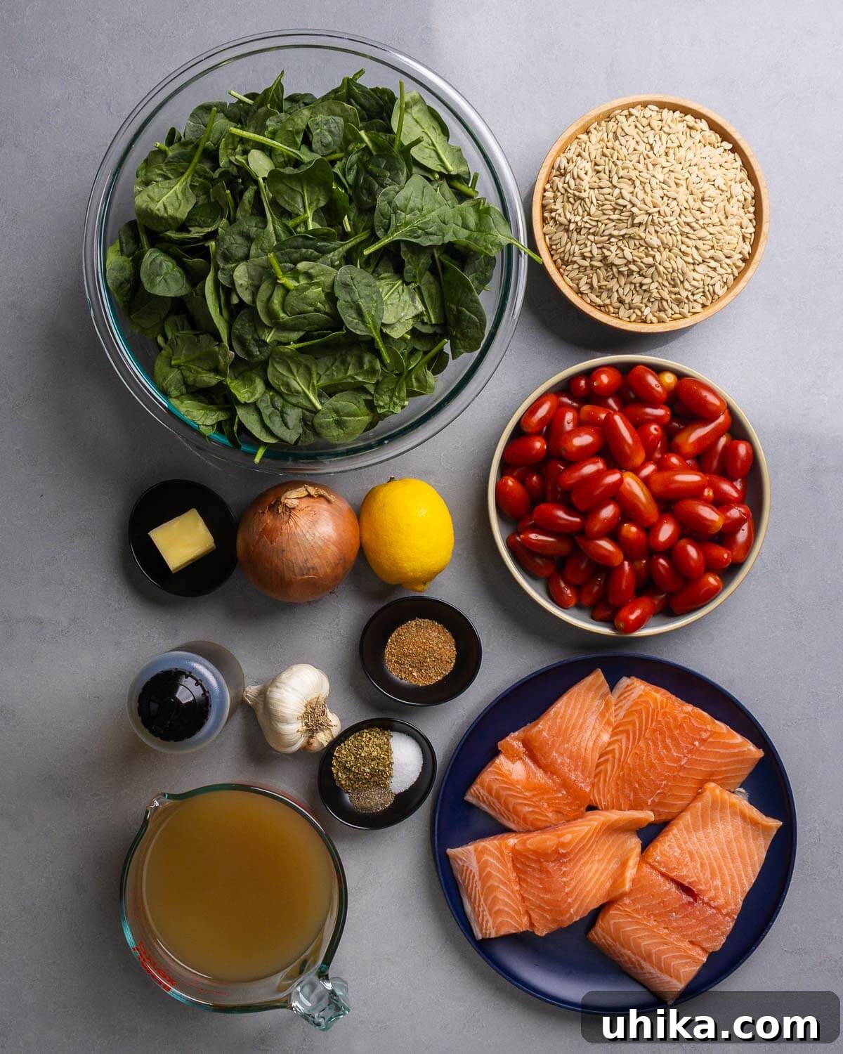 A vibrant display of fresh ingredients for the One-Pan Salmon Orzo recipe, including salmon fillets, spinach, orzo, and cherry tomatoes.