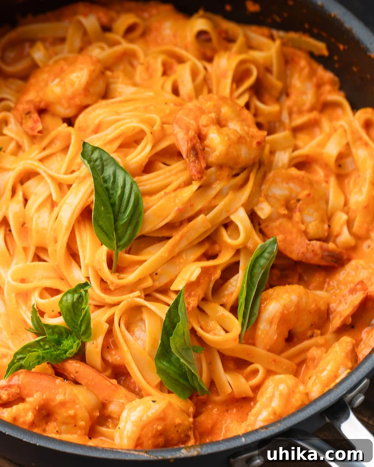 Velvety Roasted Red Pepper Shrimp Pasta 2 A vibrant bowl of creamy roasted red pepper pasta with plump shrimp, garnished with fresh basil leaves, ready to be served.