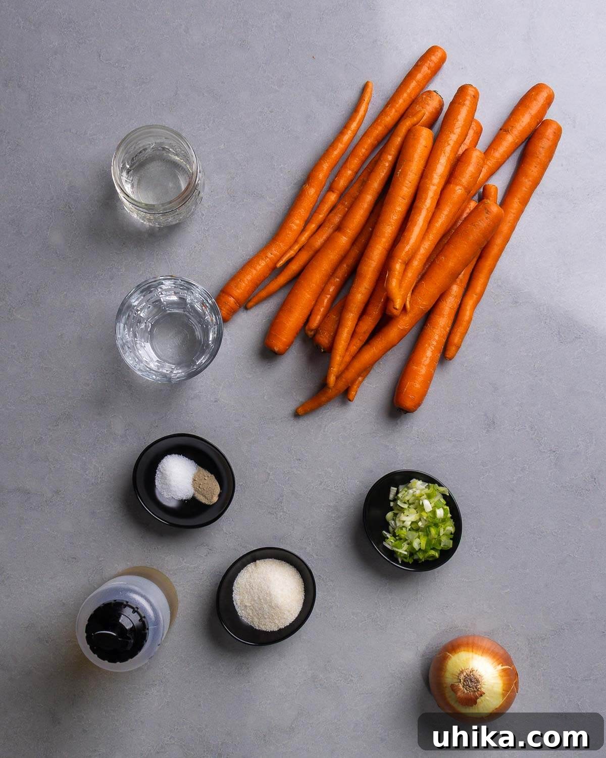 Grandma's Carrot Salad 4 Lay-flat of all ingredients required for the carrot salad recipe, including carrots, vinegar, water, salt, pepper, olive oil, sugar, green onions, and onion.