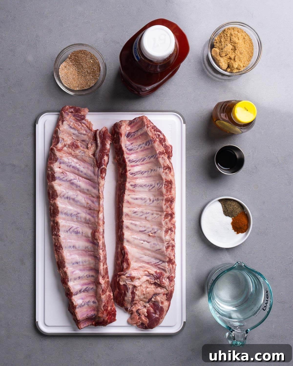 Succulent Oven Ribs with Scratch-Made BBQ 4 Ingredients for oven bbq ribs recipe: spice rub mixture, ketchup, brown sugar, honey, Worcestershire sauce, various spices, vinegar, and two racks of baby back ribs.