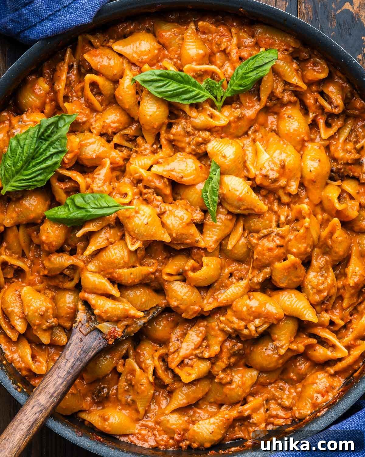 Creamy Beef and Shells Skillet Dinner 2 Creamy beef and shells pasta in large black pan, garnished with fresh basil, ready to be served.