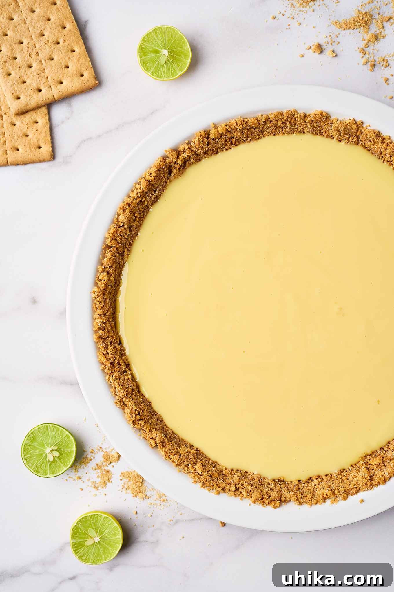Florida's Zesty Key Lime Masterpiece 5 A white pie plate with a pre-baked graham cracker crust and the key lime pie filling, ready to be baked in the oven.