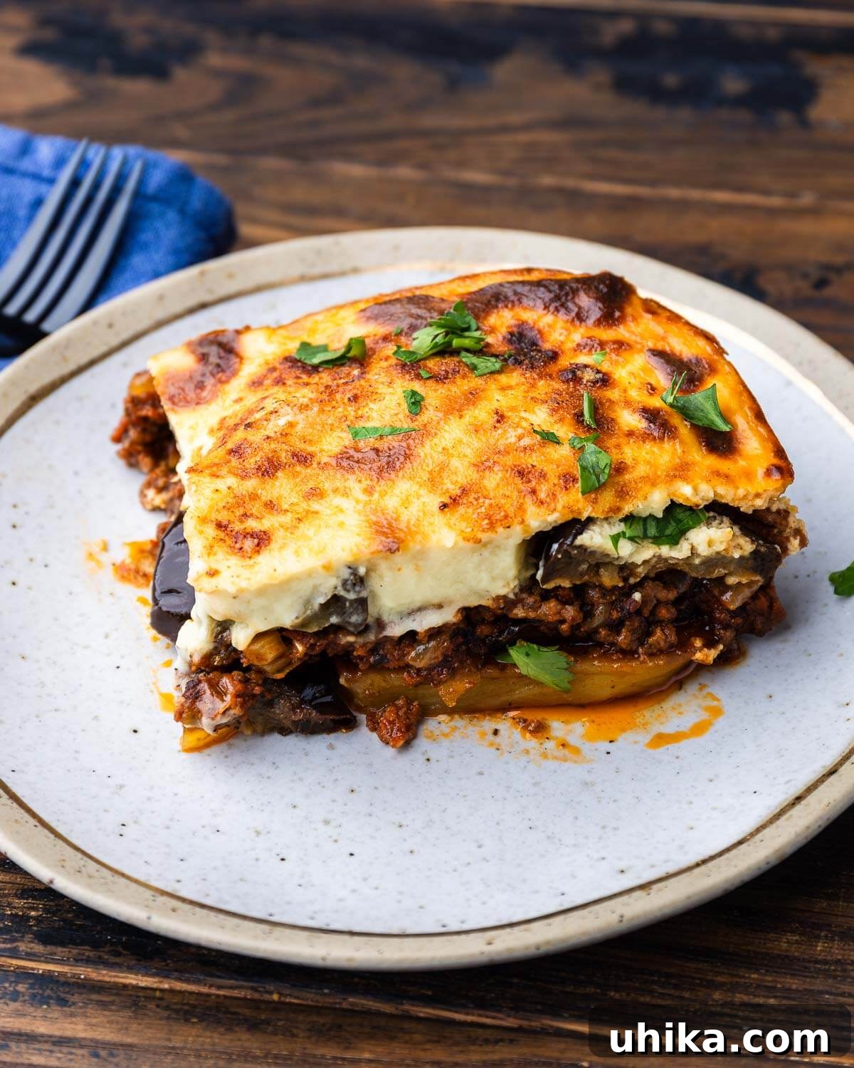Greek Moussaka The Classic Eggplant and Beef Bake 2 A perfectly portioned slice of Moussaka served on a elegant gold plate, showcasing its distinct layers.