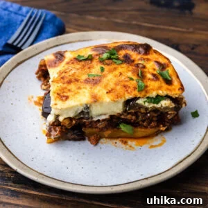 Greek Moussaka The Classic Eggplant and Beef Bake 8 Large slice of moussaka on white and gold plate.