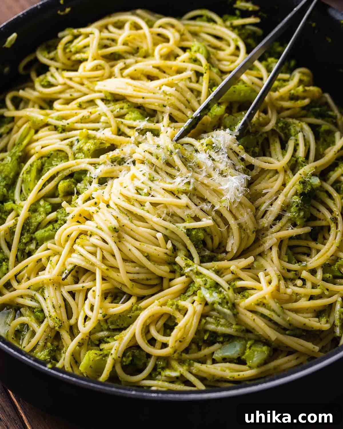 Creamy Broccoli Pasta 2 A large black pan filled with perfectly cooked spaghetti and tender broccoli florets, glistening with olive oil and garlic.