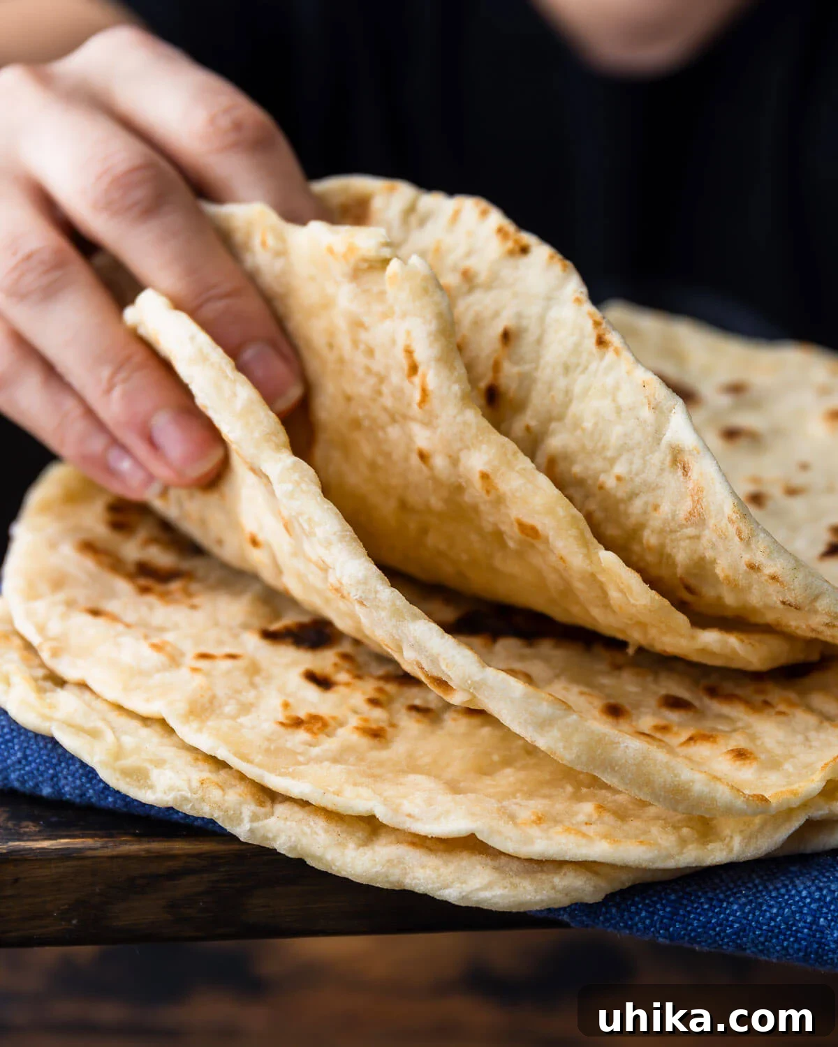 Effortless Pillowy Flatbreads 2 Hands showing a stack of golden brown, soft flatbreads, ready to be enjoyed.