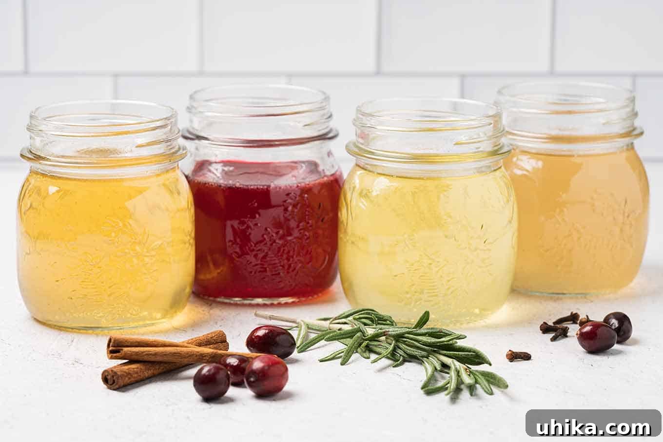 Crimson Copper Mule 3 Four glass mason jars filled with homemade holiday simple syrups orange, cranberry, rosemary, and ginger, ingredients scattered in front.