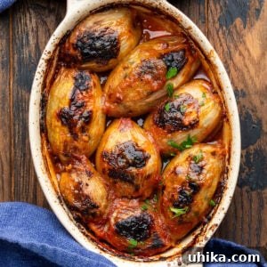 Savory Greek Onion Bake 8 Close-up of baked Greek stuffed onions, golden and bubbling in a small dish, ready to serve.