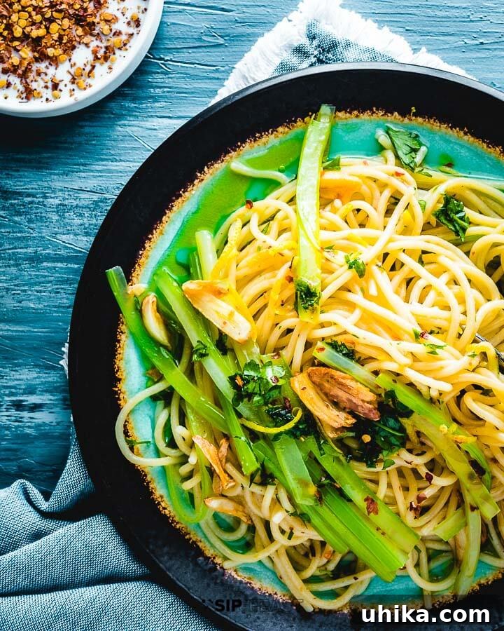 Pasta With Celery - sipandfeast.com #celery #italianpasta #dinner Overhead shot of plated spaghetti and celery on blue board.