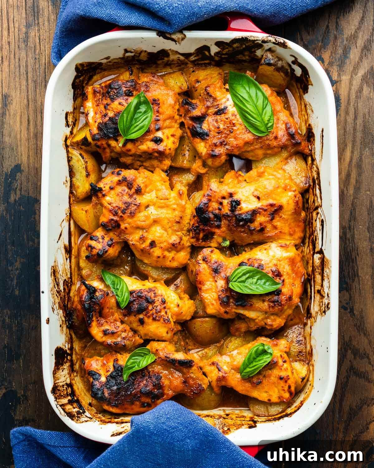 Sticky Hot Honey Chicken and Potatoes 2 Hot honey chicken and potatoes in baking dish with fresh basil garnish.