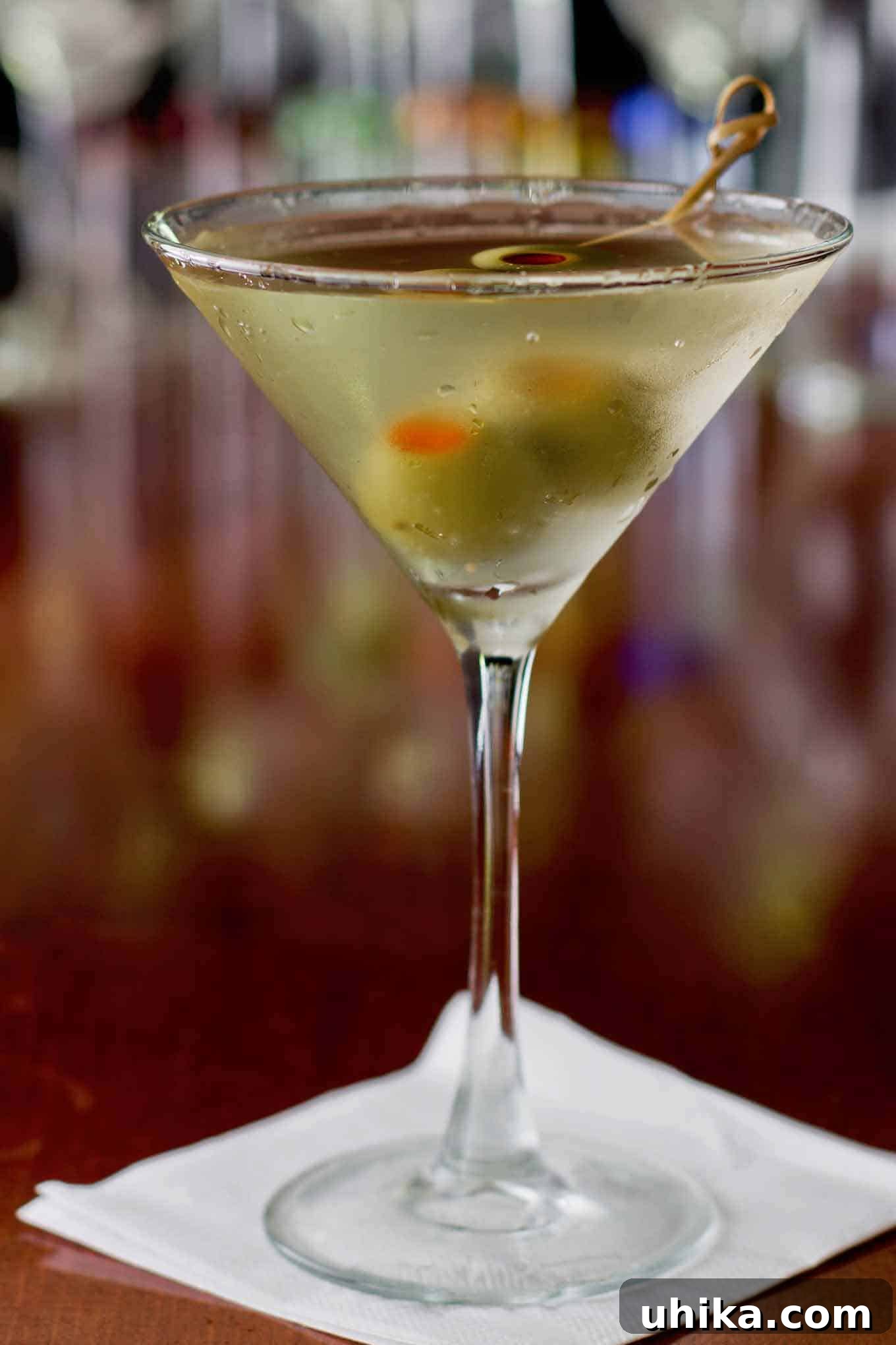 Umami Untamed 2 A perfectly chilled dirty martini cocktail, garnished with two briny green olives, reflecting sophistication and a hint of a salty tang.