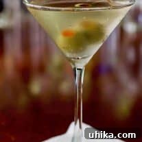 Umami Untamed 3 A pristine, chilled martini glass ready for a delicious cocktail, perfectly set on a dark, reflective surface.