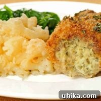 Golden-brown jalapeño-cheese stuffed chicken breast served alongside roasted vegetables.