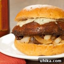 An inviting circular image of a balsamic-glazed grilled portobello mushroom burger with melted blue cheese and caramelized onions, perfectly nestled in a bun, highlighting its gourmet appeal.