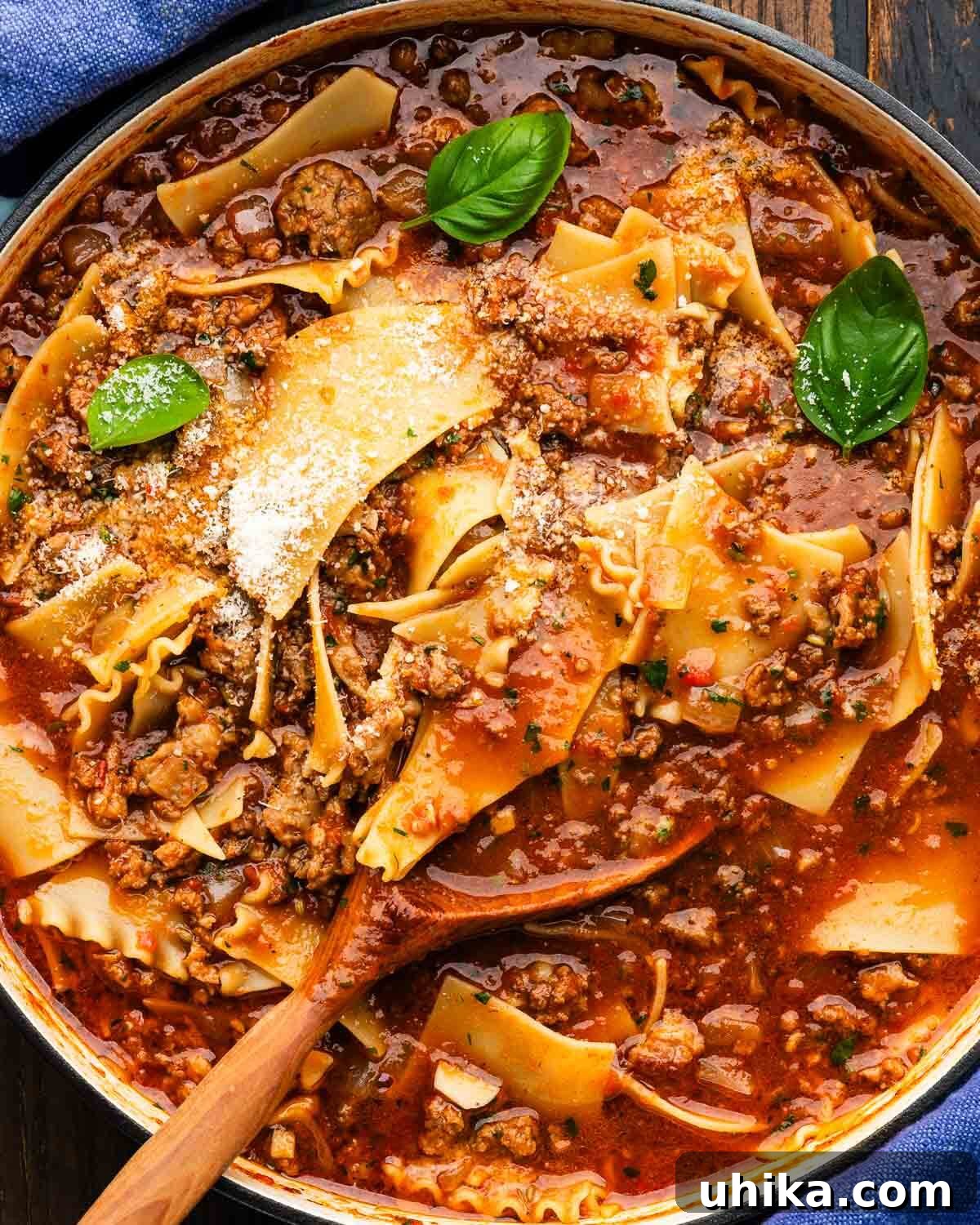 Ultimate Lasagna Soup 2 Large Dutch oven filled with rich lasagna soup, featuring broken noodles, ground meat, and a creamy swirl of ricotta, ready to be served.