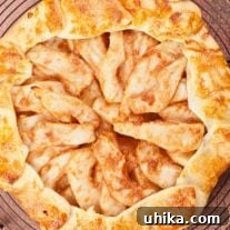 A golden brown pear galette on a round wire cooling rack ready to be cut and served.