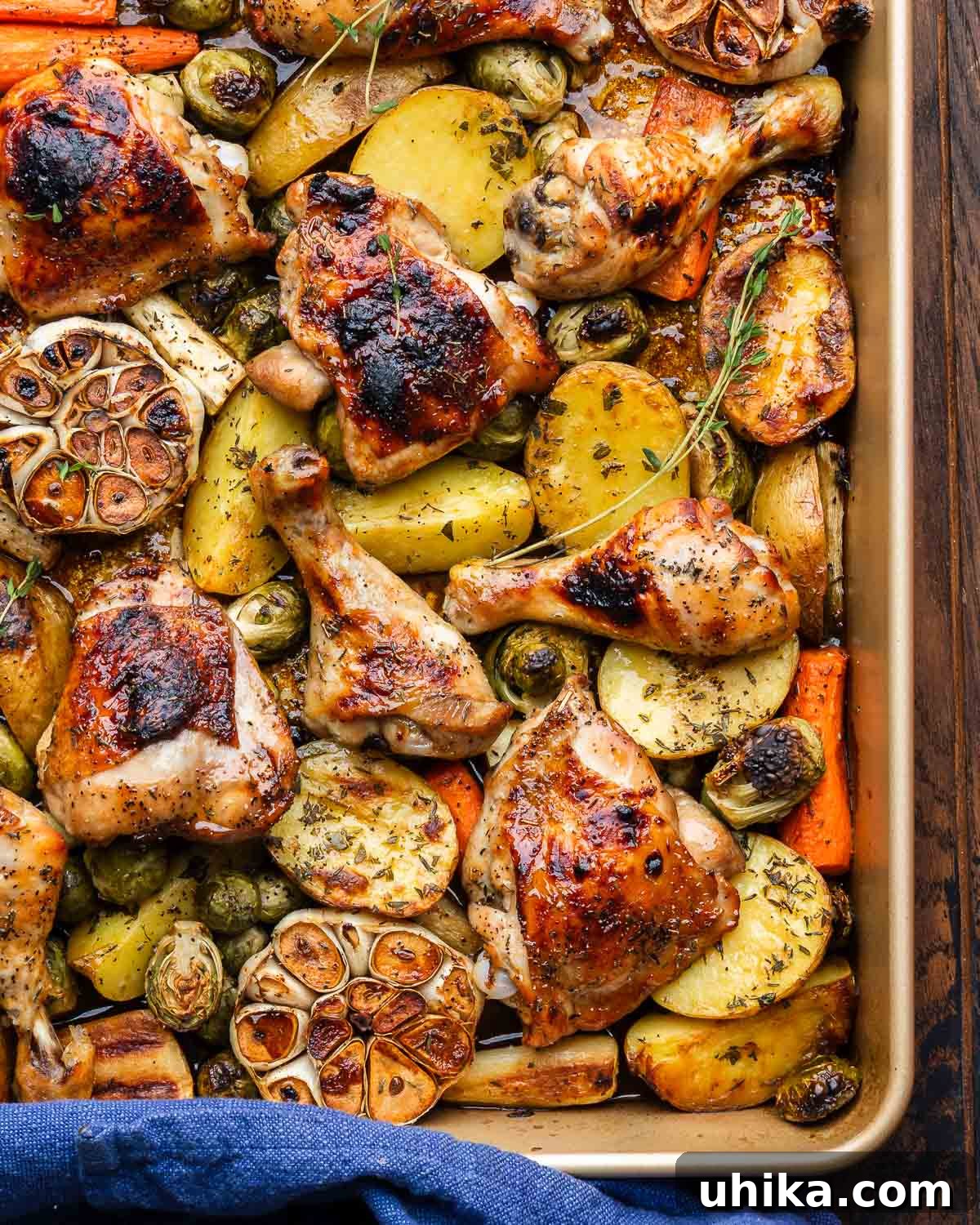 Maple Glazed Roast Chicken 2 Large baking dish with maple roasted chicken, roasted garlic, and fall vegetables, ready to be served.